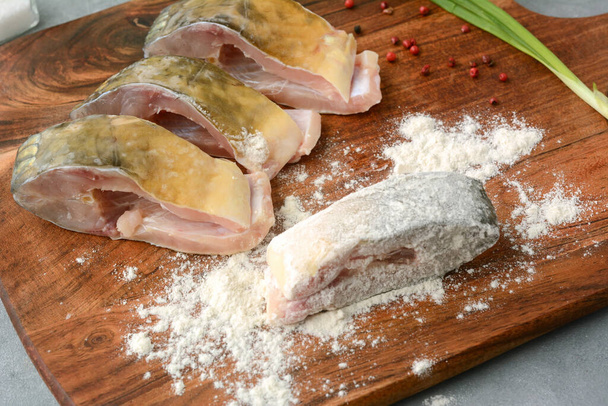 Fresh, raw carp fish slices breaded in flour. Preparing fish for frying. Traditional Polish Christmas dish - Foto, afbeelding