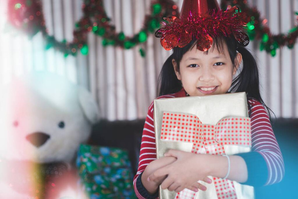 Καλά Χριστούγεννα και καλές γιορτές! Χαρούμενο κοριτσάκι χαίρεται όταν λαμβάνει και την ανταλλαγή δώρων, μικρά παιδιά που διασκεδάζουν στο σπίτι με δώρα στο δωμάτιο - Φωτογραφία, εικόνα