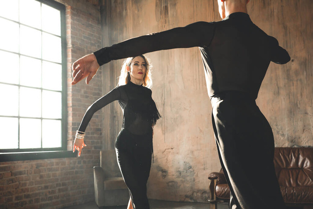 Couple of two professional ballroom dancers is dancing on loft studio. Beautiful art performance. Sport life concept. Passion and emotional dance. - Photo, Image