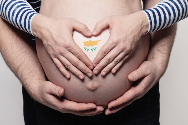 Concept de famille chypriote. Homme embrassant femme enceinte ventre et coeur avec drapeau de la République de Chypre couleurs gros plan - Photo, image