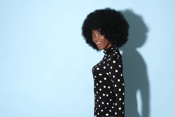 Афро-американка на светло-голубом фоне с местом для текста. - Фото, изображение