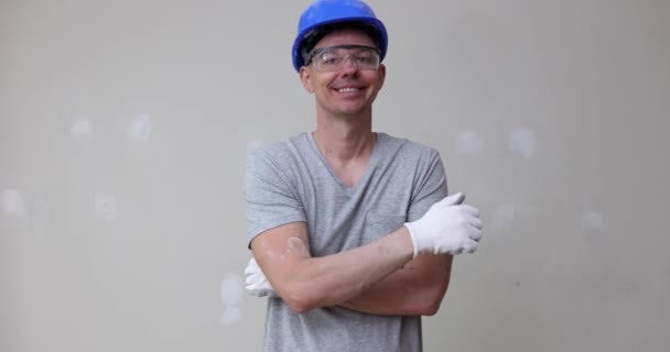 Construtor sorridente no capacete e óculos mostrando polegares até filme 4k câmera lenta. Conceito de trabalho de reparação e acabamento de qualidade profissional - Filmagem, Vídeo