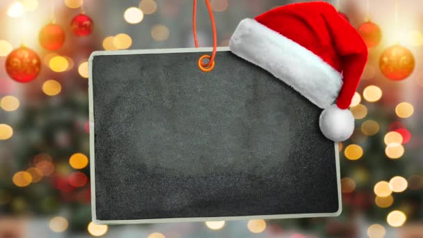 Boldog karácsonyt koncepció, átadása tábla és kalap elmosódott bokeh és fenyő fa és labdák háttér - Felvétel, videó