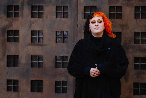 Transgénero chica con naranja pintado pelo mirando a la cámara. - Foto, Imagen