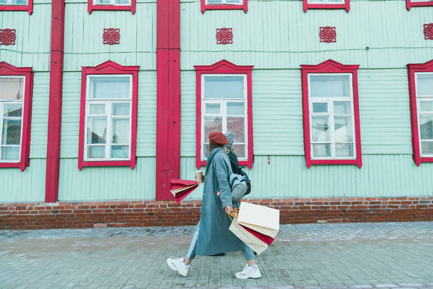 Young shopaholic friends women friends walking and carry shopping bags in the street spring or winter city with happy and smiling - purchase and free time - 写真・画像