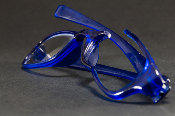 голубые разбитые очки на черном фоне
 - Фото, изображение