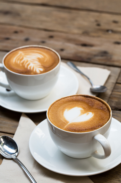filiżanka gorącej kawy sztuki latte na drewnianym stole - Zdjęcie, obraz