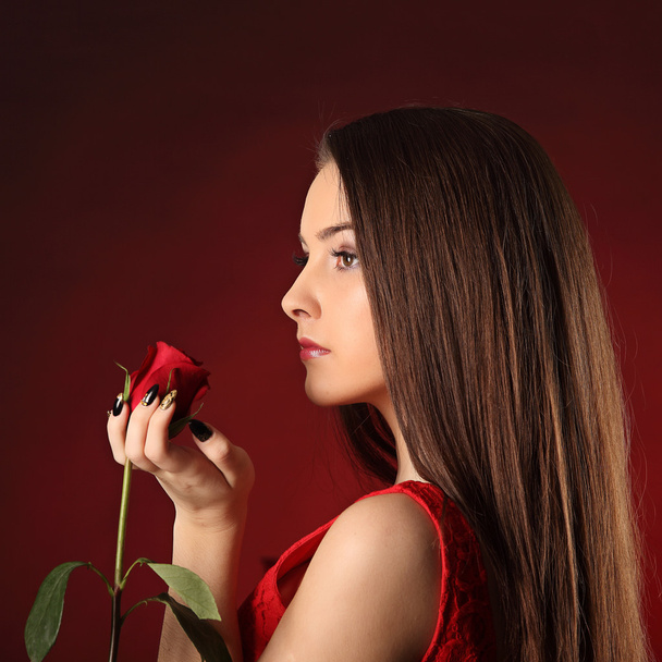 San Valentín hermosa chica con rosa roja en sus manos
 - Foto, imagen
