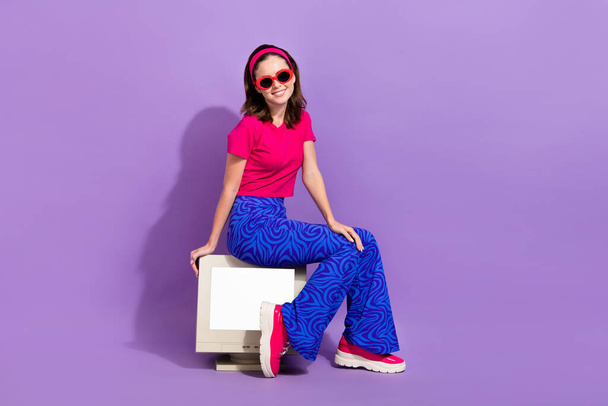 Photo of cheerful adorable lady wear trendy clothes sit old gadget recommend device shop empty space isolated on purple color background. - Zdjęcie, obraz