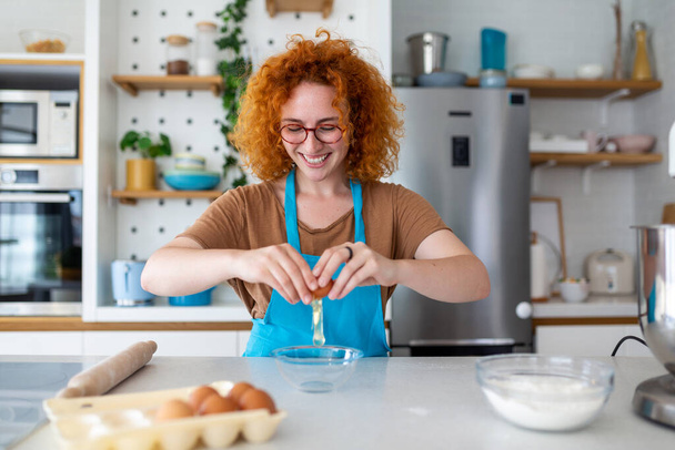 Koncepcja pieczenia. Portret radosnej kobiety Kneading Ciasto we wnętrzu kuchni, Wesoła kobieta w fartuchu zabawy podczas przygotowywania domowego ciasta, - Zdjęcie, obraz