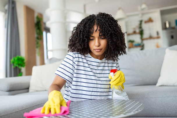 Mulher limpeza e polimento da mesa com um detergente spray, limpeza e conceito de higiene - Foto, Imagem