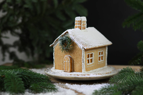 Piękny ręcznie robiony domek z piernika na Boże Narodzenie i Nowy Rok, ciemne zaplecze, selektywna ostrość. Wysokiej jakości zdjęcie - Zdjęcie, obraz