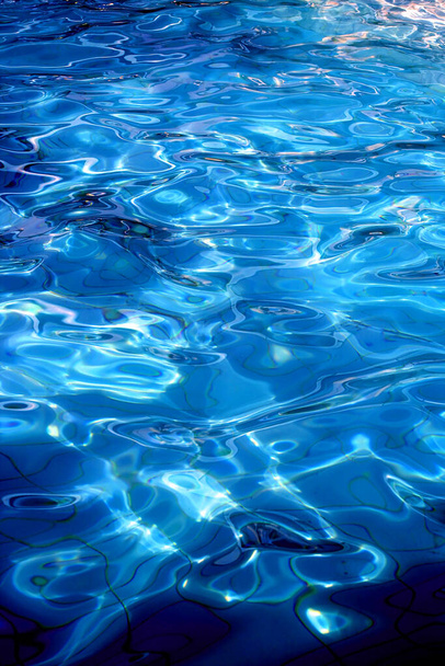Zonlicht op een blauw zwembad - Foto, afbeelding