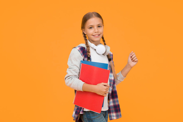 Study lessons for exam. find inspiration in music. Enjoying elearning. modern education concept. little girl in headphones with notepad. back to school. hipster child at school. childhood happiness. - Photo, Image