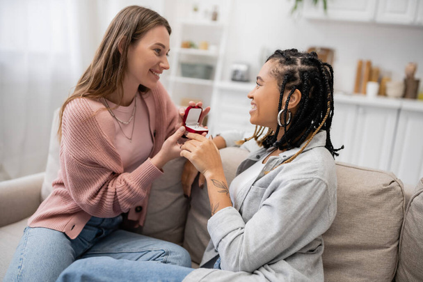 lesbian woman making proposal to happy african american girlfriend on valentines day - Photo, Image