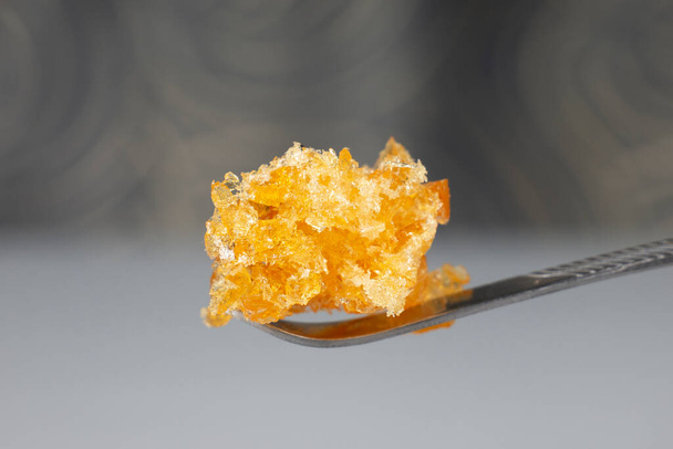 cristales de cera de cannabis de oro en el palo dab, alto thc marihuana se desmoronan - Foto, imagen