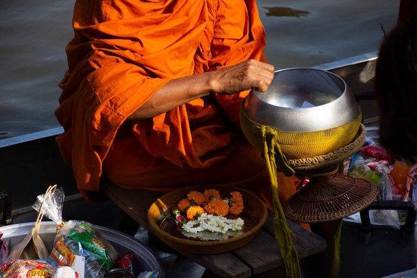 Таїландці подорожують за кордоном і приєднуються до традицій, які заслуговують на ритуал, і моляться, щоб дати милостиню ченцям на човні в каналі Ват Сай Яй 8 листопада 2022 року в Нетабурі Таїланд - Фото, зображення