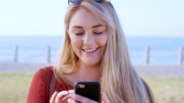 Woman, face or laughing at phone by beach, ocean or sea on summer break, vacation holiday or travel location. Smile, happy or comic tourist, student or person on mobile technology or social media app. - 映像、動画