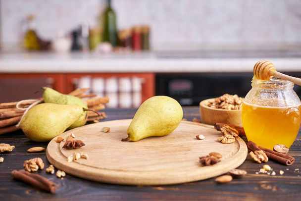 Ripe organic pear on the wooden cutting board Board at domestic kitchen. - Φωτογραφία, εικόνα