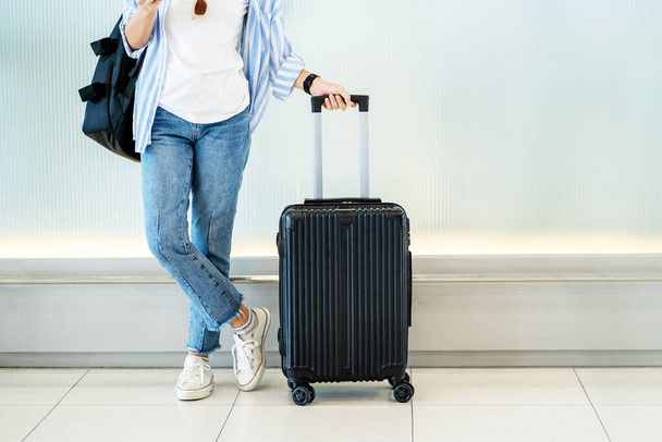 Asian woman teenager using smartphone at airport terminal standing with luggage suitcase and backpack for travel in vacation summer. - Foto, Bild