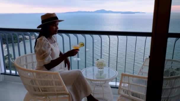 Aziatische vrouwen dronken cocktails op het balkon van een hotel in Pattaya Thailand tijdens zonsondergang - Video