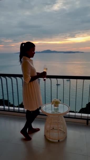 Aziatische vrouwen dronken champagne op het balkon van een hotel in Pattaya Thailand tijdens zonsondergang - Video