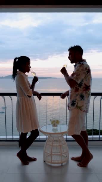 Enkele Europese mannen en Thaise vrouwen dronken cocktails op het balkon van een hotel in Pattaya Thailand.  - Video