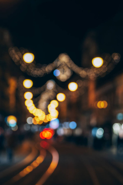 Νυχτερινός δρόμος διακοσμημένος με φώτα διακοπών, θολή φόντο. - Φωτογραφία, εικόνα