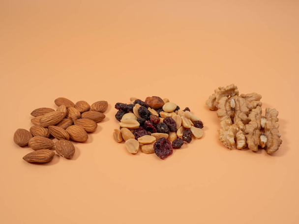 Various nuts on an orange background. Mixed nuts. Close-up. - Photo, Image