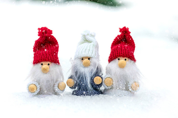 クリスマスの休日カード雪の冬の森の中で赤、白の帽子とひげを持つかわいいスカンディナヴィアのノームおとぎ話の降雪冬こんにちは12月、 1月、 2月のコンセプトハッピーニューイヤー、クリスマス. - 写真・画像