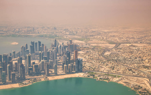 Widok z lotu z samolotu na dauhańską panoramę. Korniszowe i nowoczesne budynki, Katar. - Zdjęcie, obraz
