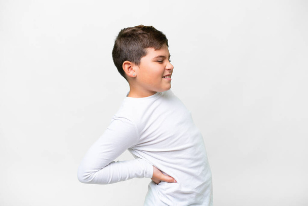 Маленький кавказский ребенок на изолированном белом фоне страдает от боли в спине за то, что сделал усилие - Фото, изображение