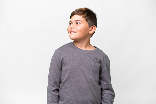 Little caucasian kid over isolated white background looking to the side and smiling - Valokuva, kuva