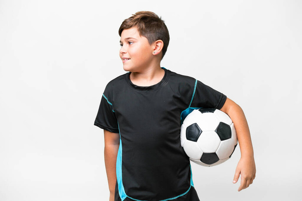 Μικρή καυκάσιος ποδοσφαιριστής παιδί πάνω από απομονωμένο λευκό φόντο αναζητούν πλευρά - Φωτογραφία, εικόνα