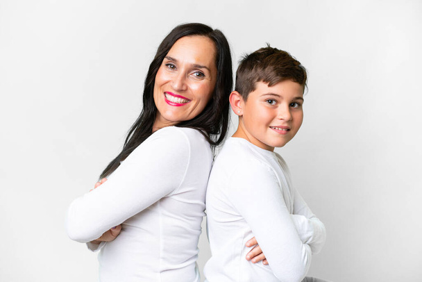 Little caucasian kid with his mother over isolated white background keeping arms crossed - Fotoğraf, Görsel