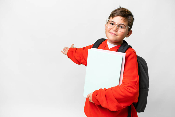 Little caucasian student kid over isolated background extending hands to the side for inviting to come - Foto, Bild