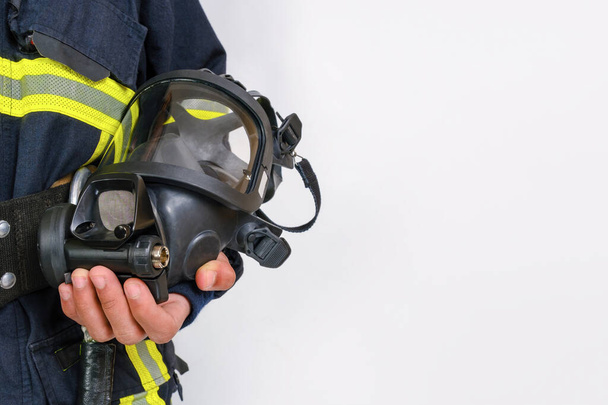 Full protective breathing air mask in hand of unrecognized african-american firefighter, rescue and fire fighter equipment isolated on white background, copy space - Photo, Image