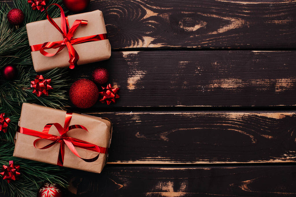 Κορυφή φωτογραφία προβολή Christmass flatlay κουτιά δώρων, κόκκινα παιχνίδια χριστουγεννιάτικο δέντρο και ερυθρελάτης brance σε ξύλινο φόντο. Xmas φόντο με χώρο για text.Copyspace. - Φωτογραφία, εικόνα