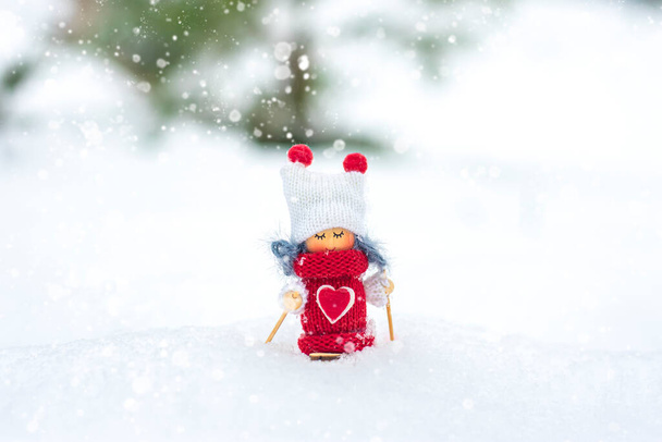 Brinquedo de esquiador menina em cachecol e chapéu de malha esquiando brinquedo de elfo em esquis na paisagem nevada Ano Novo, Feliz Natal cartão de saudação inverno Feliz Ano Novo Olá Dezembro, Janeiro, Fevereiro. - Foto, Imagem