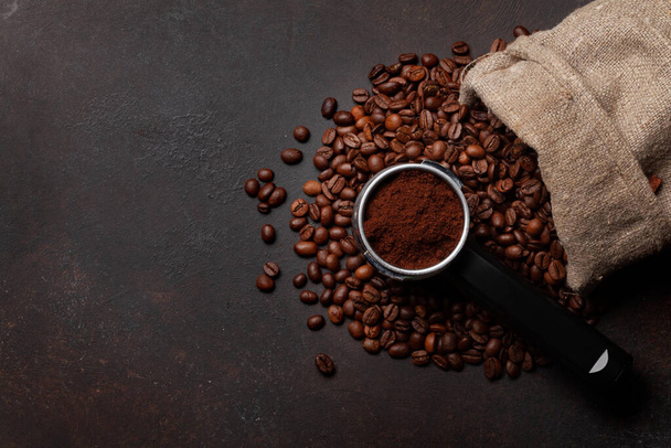 Paahdettuja kahvipapuja ja jauhettua kahvia suodatinpidikkeessä. Top View tasainen makasi kopioi tilaa - Valokuva, kuva