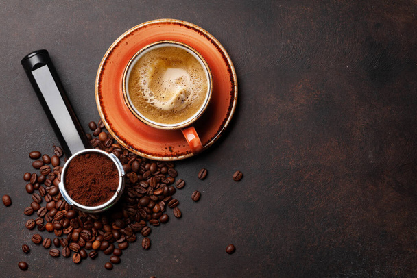 焙煎したコーヒー豆、フィルターホルダーとエスプレッソカップで挽いたコーヒー。コピースペース付きのトップビューフラットレイ - 写真・画像