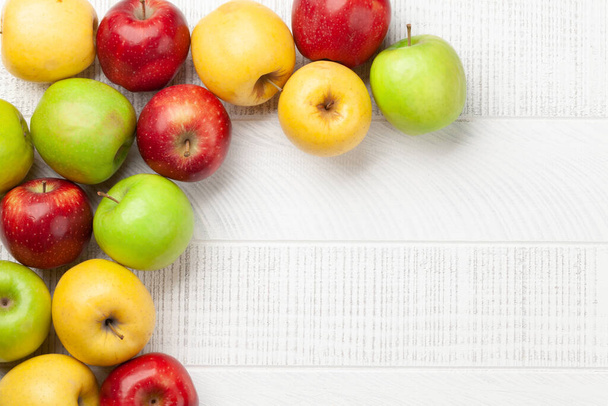 Frutas de maçã maduras coloridas na mesa de madeira. Top vista plana leigos com espaço de cópia - Foto, Imagem