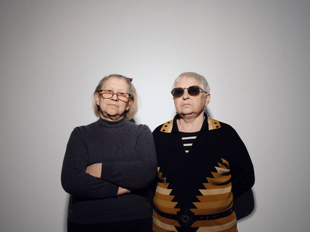 Két vidám libériai nagymama néz a kamerába, és tiszta háttérrel mosolyognak. - Fotó, kép