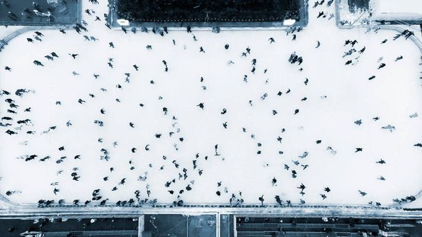 Top näkymä ihmiset luistelevat suuri ulkona luistinrata talvipäivänä. Antenni Drone View Lento Yli väkijoukon ihmiset luistella jäähalli. Talviaktivitee Luistelutausta. Kaupungin jäähalli. Sininen väri - Valokuva, kuva