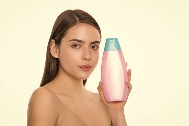 presenting female cosmetic product. woman use shampoo. young girl hold hair conditioner. lady with body lotion. daily habit and personal care. youth skincare beauty cosmetic. shower gel. - Foto, Imagem