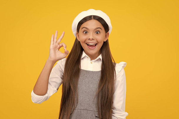 Portrait of teen girl making ok gesture, isolated background. Young teenager smiling and giving okey sign. Happy cute child showing okay. Excited face, cheerful emotions of teenager girl - Foto, Imagen