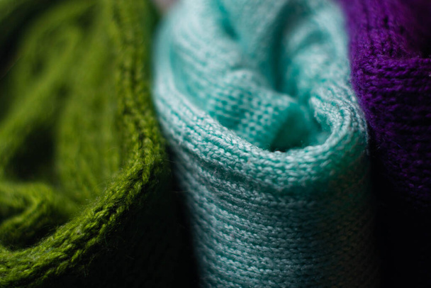 Des pulls tricotés confortables de différentes couleurs sont empilés les uns sur les autres - Photo, image
