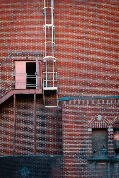 Charlotte, NC 'de çelik merdivenleri ve açık kapısı olan eski tuğla bina.. - Fotoğraf, Görsel