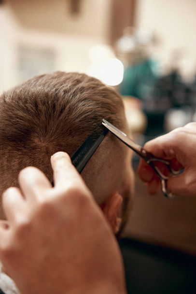Barber shaving handsome bearded man in barber shop. - Фото, зображення