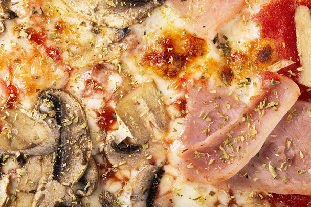 Domowej roboty pizza z szynką i grzybami jako tło. Mało brakowało na pizzę. Zdjęcie makro. Włoska pizza capricciosa. Zbliżenie - Zdjęcie, obraz